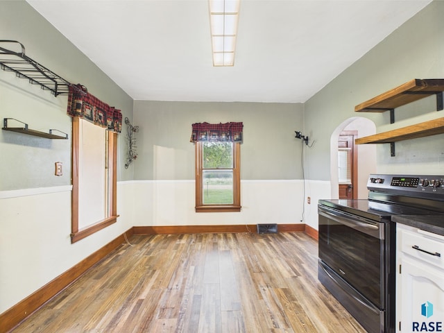 45390 284th St, Hurley, SD 57036 - kitchen featuring electric range, open shelves, arched walkways, wood finished floors, and white cabinets