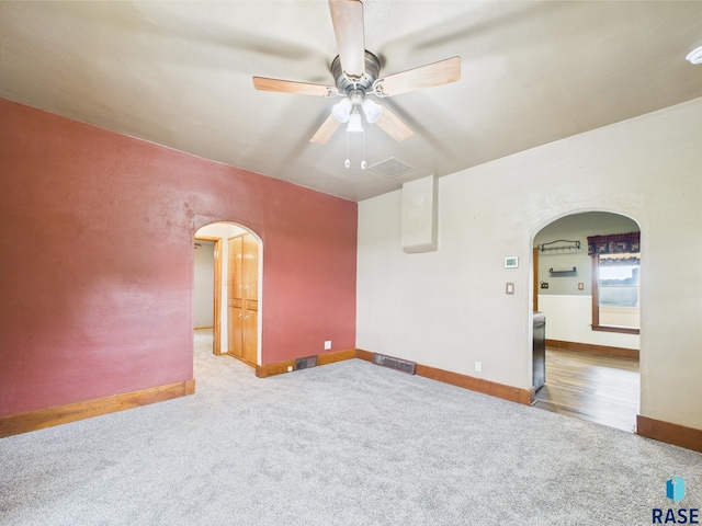 45390 284th St, Hurley, SD 57036 - carpeted empty room featuring arched walkways, a ceiling fan, and baseboards