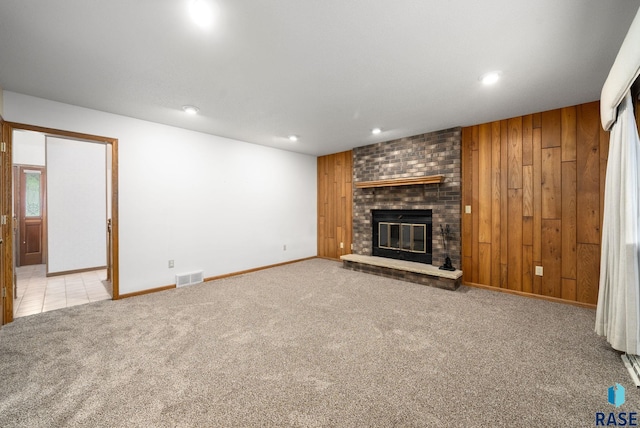 4704 S Pasque Cir, Sioux Falls, SD 57105 - unfurnished living room with carpet floors, a brick fireplace, recessed lighting, baseboards, and wood walls