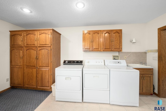 4704 S Pasque Cir, Sioux Falls, SD 57105 - washroom featuring washer and dryer, cabinet space, a textured ceiling, recessed lighting, and light tile patterned floors