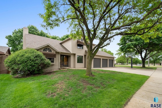 4704 S Pasque Cir, Sioux Falls, SD 57105 - view of front of home with a front yard, driveway, a chimney, and roof with shingles