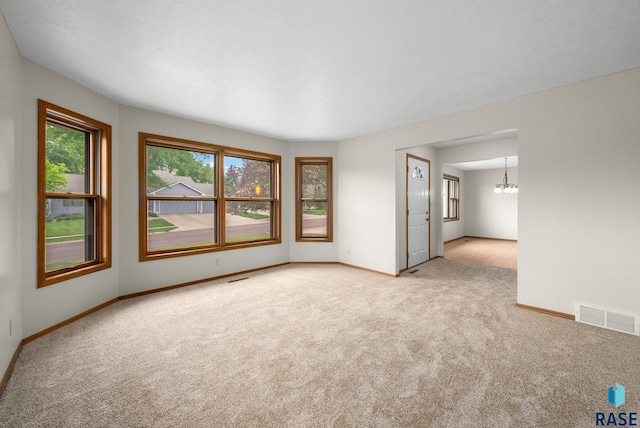 909 E 64th St, Sioux Falls, SD 57108 - empty room featuring light carpet, a chandelier, and baseboards