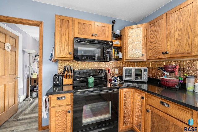 48484 262nd St, Valley Springs, SD 57068 - kitchen with black appliances, dark countertops, brown cabinets, and decorative backsplash