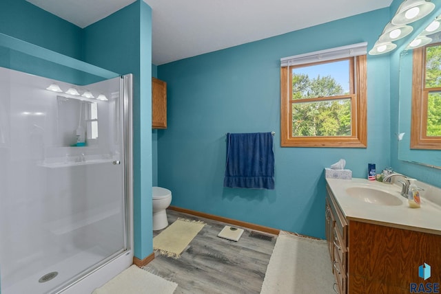 48484 262nd St, Valley Springs, SD 57068 - bathroom featuring vanity, a shower stall, toilet, wood finished floors, and baseboards