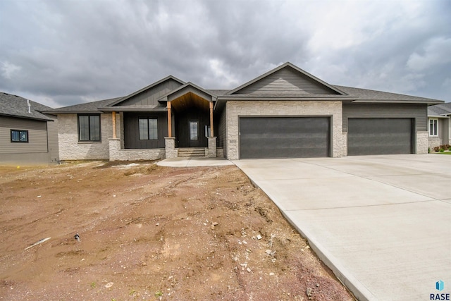 6504 E Hawker Trl, Sioux Falls, SD 57110 - view of front of property featuring an attached garage, driveway, board and batten siding, and stone siding
