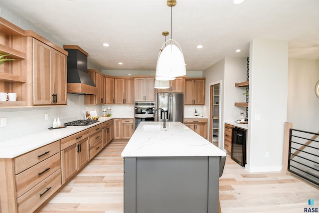 6504 E Hawker Trl, Sioux Falls, SD 57110 - kitchen featuring open shelves, stainless steel appliances, wall chimney range hood, light wood-style floors, and an island with sink