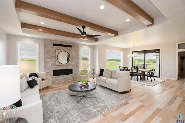 6504 E Hawker Trl, Sioux Falls, SD 57110 - living area with beamed ceiling, plenty of natural light, light wood-style floors, a ceiling fan, and a stone fireplace