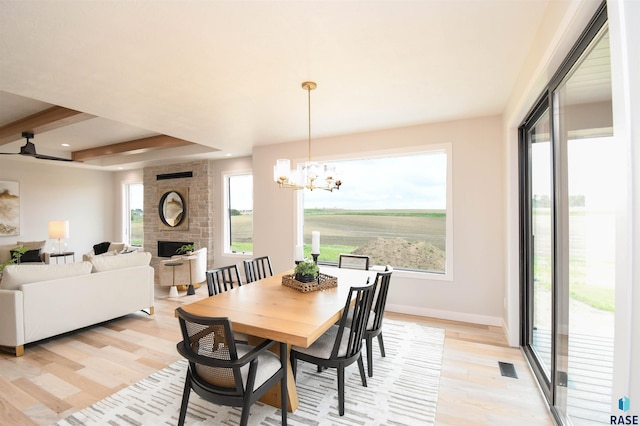6504 E Hawker Trl, Sioux Falls, SD 57110 - dining room with light wood-style floors, a fireplace, a chandelier, baseboards, and recessed lighting