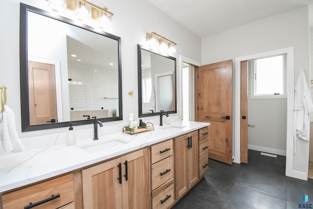 6504 E Hawker Trl, Sioux Falls, SD 57110 - bathroom featuring double vanity, a tile shower, and baseboards