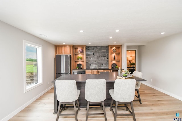 6504 E Hawker Trl, Sioux Falls, SD 57110 - kitchen with freestanding refrigerator, open shelves, dark countertops, light wood-type flooring, and a sink