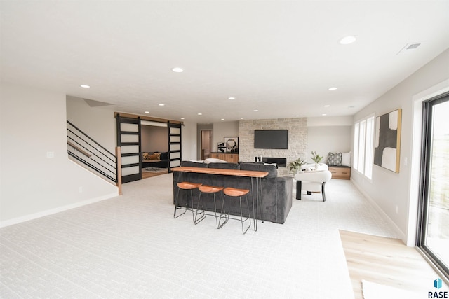 6504 E Hawker Trl, Sioux Falls, SD 57110 - living room with recessed lighting, a stone fireplace, baseboards, stairway, and a barn door