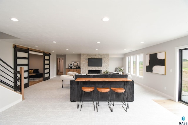 6504 E Hawker Trl, Sioux Falls, SD 57110 - living area featuring a barn door, recessed lighting, light colored carpet, baseboards, and a fireplace