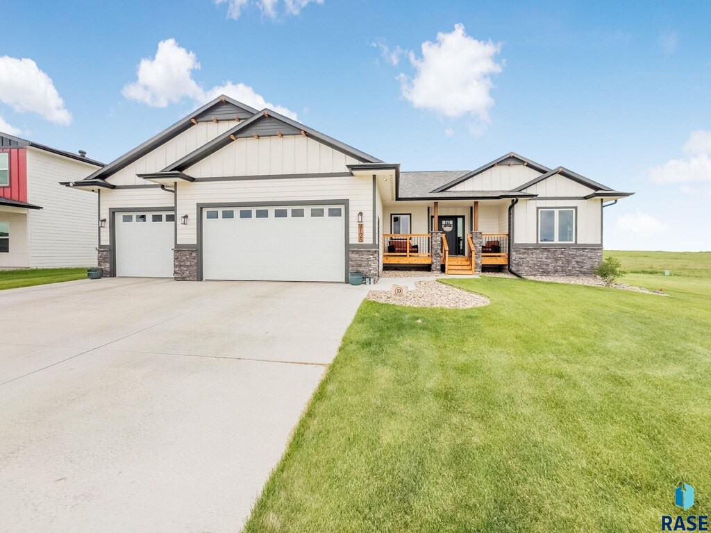 4125 N Interlachen Trl, Sioux Falls, SD 57107 - craftsman house featuring board and batten siding, stone siding, a porch, and a garage