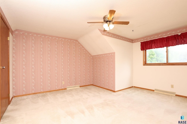 6905 W 6th St, Sioux Falls, SD 57107 - additional living space featuring carpet flooring, a ceiling fan, a baseboard radiator, baseboards, and vaulted ceiling