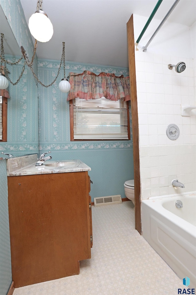 6905 W 6th St, Sioux Falls, SD 57107 - bathroom with vanity, toilet, bathing tub / shower combination, wallpapered walls, and tile patterned floors