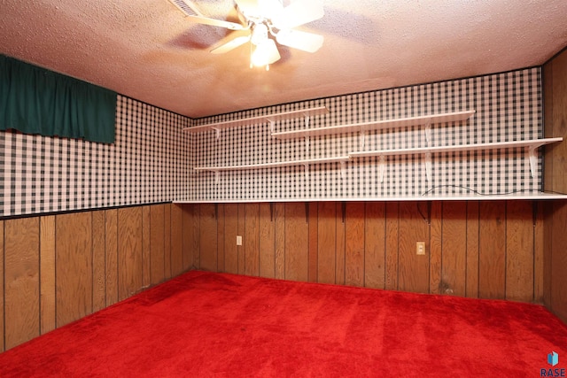 6905 W 6th St, Sioux Falls, SD 57107 - spare room featuring wooden walls, a textured ceiling, a ceiling fan, and carpet floors