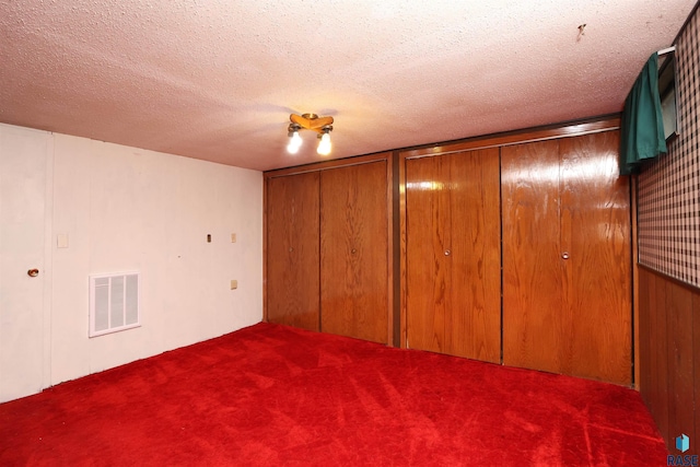 6905 W 6th St, Sioux Falls, SD 57107 - unfurnished bedroom with carpet, multiple closets, and a textured ceiling