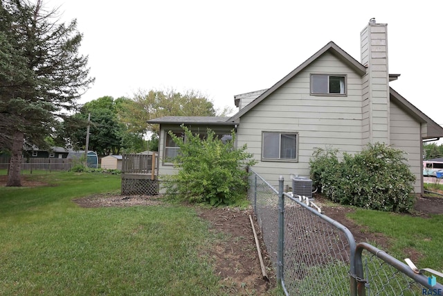 6905 W 6th St, Sioux Falls, SD 57107 - view of side of home featuring a chimney, central air condition unit, a wooden deck, and a shingled roof