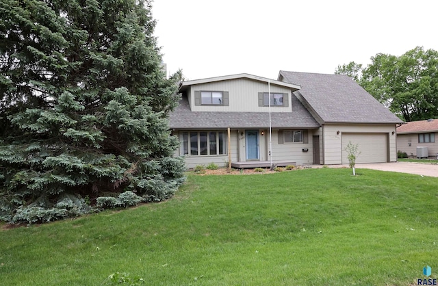 6905 W 6th St, Sioux Falls, SD 57107 - view of front of house with an attached garage, driveway, a front lawn, cooling unit, and a shingled roof