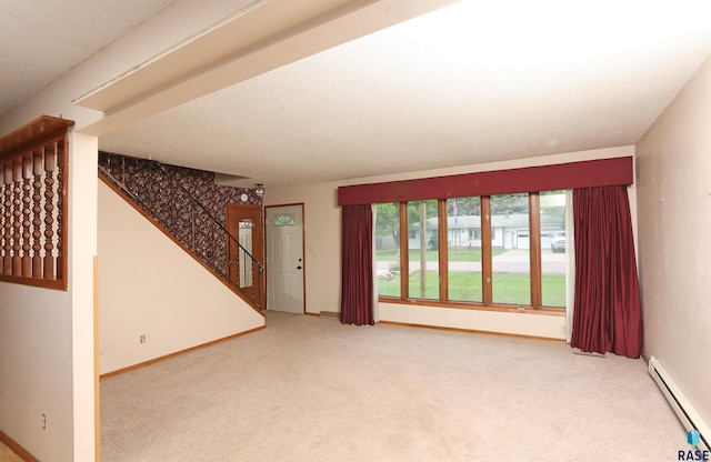 6905 W 6th St, Sioux Falls, SD 57107 - unfurnished living room featuring a baseboard heating unit, stairway, carpet flooring, baseboards, and a textured ceiling