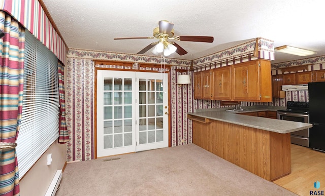 6905 W 6th St, Sioux Falls, SD 57107 - kitchen with electric stove, wallpapered walls, under cabinet range hood, freestanding refrigerator, and a peninsula