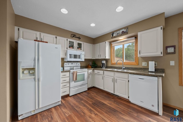 4401 E 28th St, Sioux Falls, SD 57103 - kitchen featuring white appliances, a sink, white cabinets, dark countertops, and dark wood-type flooring
