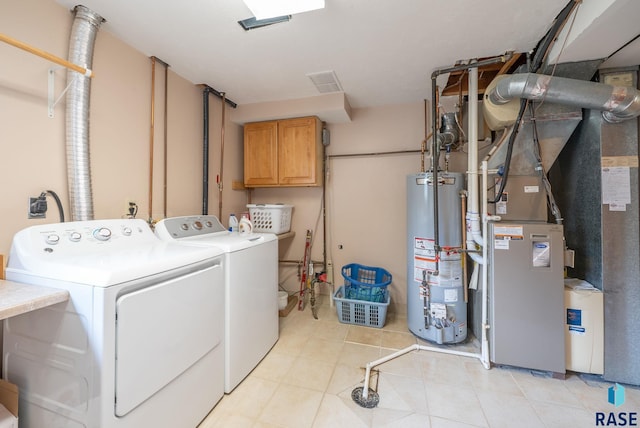 4401 E 28th St, Sioux Falls, SD 57103 - laundry room featuring gas water heater, washer and clothes dryer, cabinet space, light tile patterned floors, and heating unit