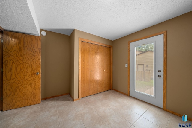 4401 E 28th St, Sioux Falls, SD 57103 - unfurnished bedroom featuring a textured ceiling, a closet, baseboards, and light tile patterned floors