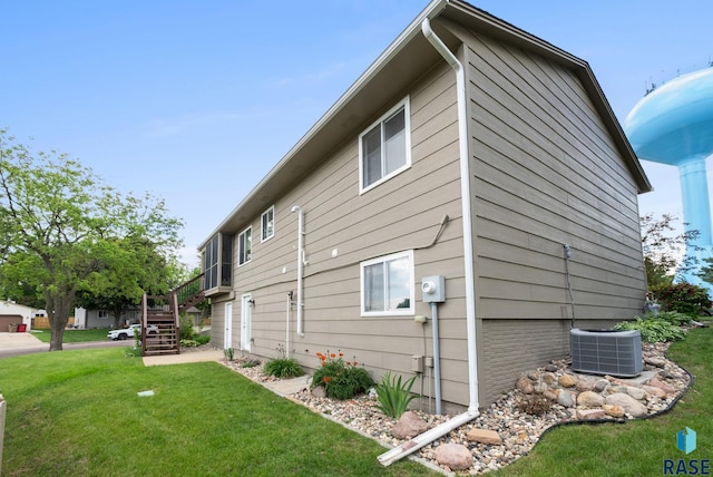 4401 E 28th St, Sioux Falls, SD 57103 - view of property exterior featuring central AC unit, a lawn, and stairway