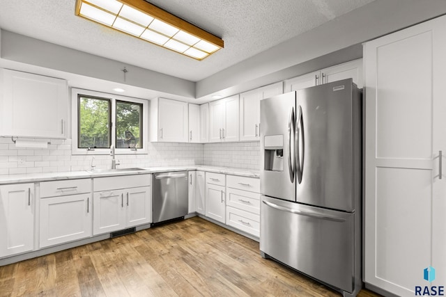 4804 W 39th St, Sioux Falls, SD 57106 - kitchen with stainless steel appliances, white cabinets, a textured ceiling, backsplash, and a sink