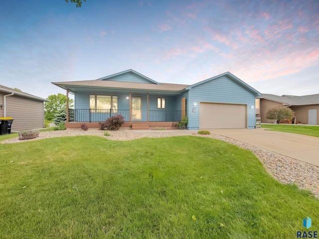 201 N Foss Ave, Sioux Falls, SD 57110 - ranch-style house with covered porch, an attached garage, a yard, and concrete driveway