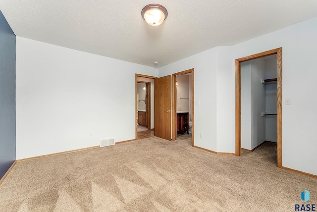 201 N Foss Ave, Sioux Falls, SD 57110 - unfurnished bedroom with a spacious closet, carpet, baseboards, a closet, and connected bathroom