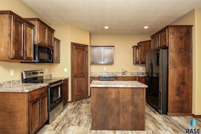 6400 S Keller Cir, Sioux Falls, SD 57108 - kitchen with black appliances, a sink, light wood-style flooring, a center island, and recessed lighting