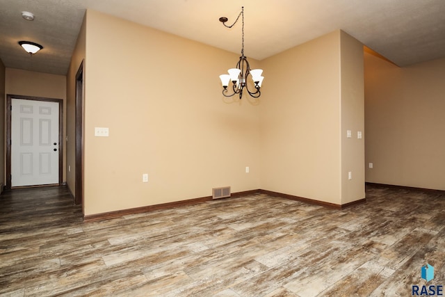 6400 S Keller Cir, Sioux Falls, SD 57108 - spare room featuring wood finished floors, a chandelier, and baseboards