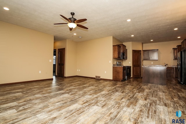 6400 S Keller Cir, Sioux Falls, SD 57108 - unfurnished living room with dark wood finished floors, recessed lighting, ceiling fan, baseboards, and a sink