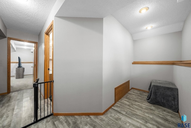 800 N Poplar Ave, Tea, SD 57064 - hall featuring a textured ceiling, wood finished floors, baseboards, and vaulted ceiling