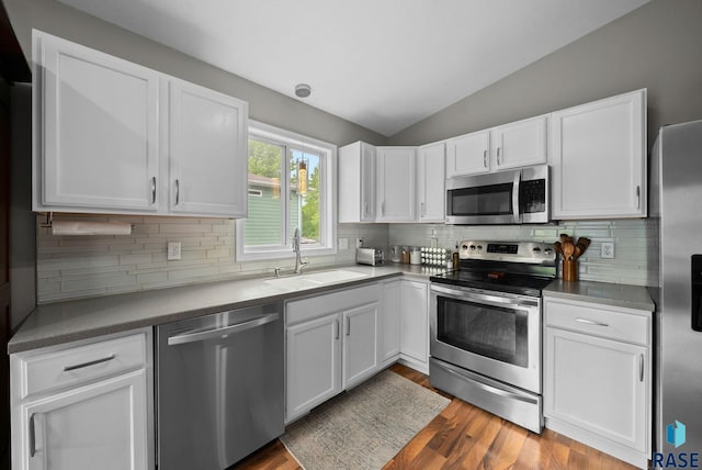 800 N Poplar Ave, Tea, SD 57064 - kitchen featuring stainless steel appliances, a sink, vaulted ceiling, white cabinetry, and wood finished floors