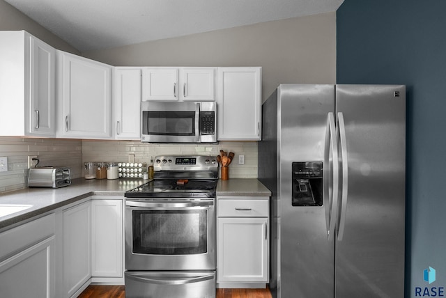 800 N Poplar Ave, Tea, SD 57064 - kitchen featuring appliances with stainless steel finishes, lofted ceiling, backsplash, and white cabinetry