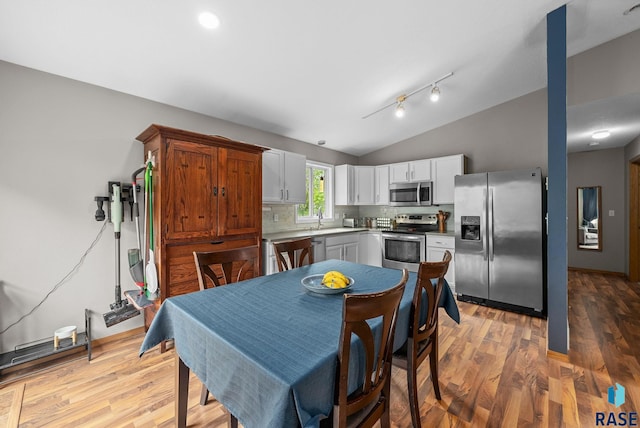 800 N Poplar Ave, Tea, SD 57064 - kitchen with stainless steel appliances, vaulted ceiling, decorative backsplash, wood finished floors, and white cabinetry