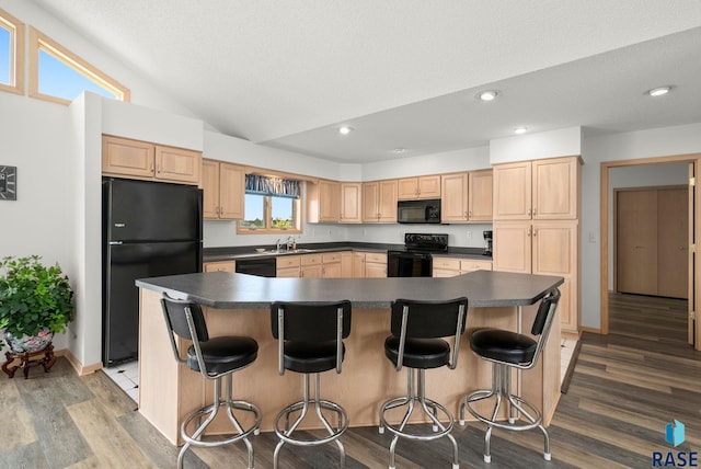 200 Best Point Dr, Madison, SD 57042 - kitchen featuring black appliances, light brown cabinets, dark countertops, recessed lighting, and lofted ceiling