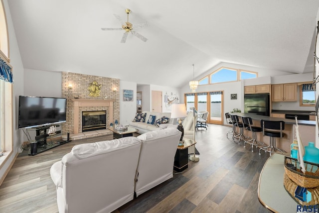 200 Best Point Dr, Madison, SD 57042 - living area featuring lofted ceiling, healthy amount of natural light, ceiling fan, wood finished floors, and a brick fireplace