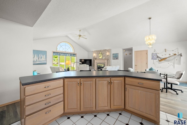 200 Best Point Dr, Madison, SD 57042 - kitchen featuring dark countertops, a ceiling fan, a fireplace, a chandelier, and lofted ceiling
