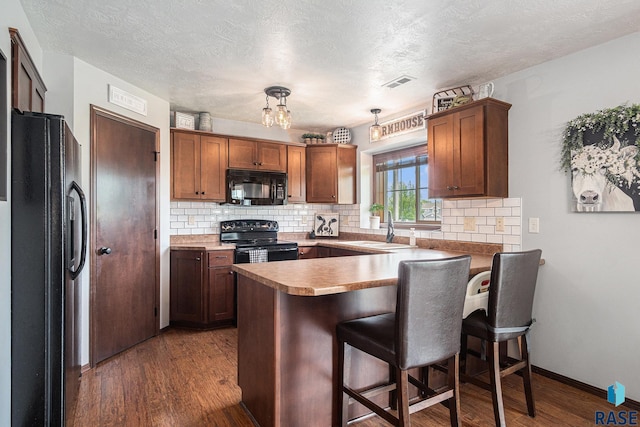5300 W Sourwood Pl, Sioux Falls, SD 57107 - kitchen with black appliances, a sink, a peninsula, decorative backsplash, and a textured ceiling