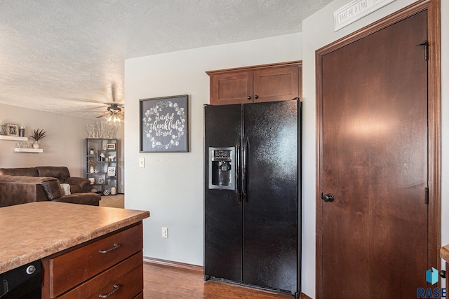 5300 W Sourwood Pl, Sioux Falls, SD 57107 - kitchen with black fridge with ice dispenser, dark wood-style flooring, a ceiling fan, a textured ceiling, and light countertops