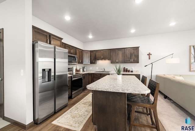 9054 W Ark Pl, Sioux Falls, SD 57106 - kitchen featuring appliances with stainless steel finishes, dark brown cabinetry, light countertops, wood finished floors, and a kitchen island