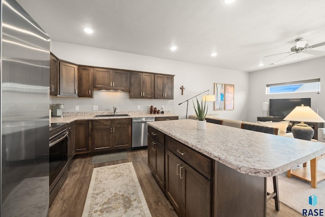 9054 W Ark Pl, Sioux Falls, SD 57106 - kitchen with appliances with stainless steel finishes, a sink, dark brown cabinetry, dark wood-style floors, and light countertops