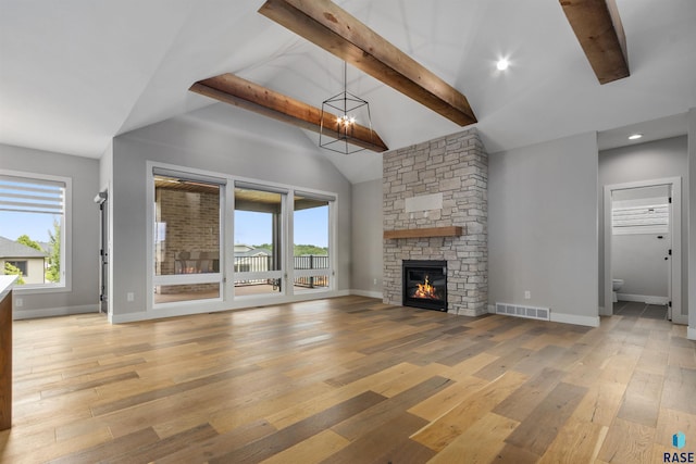 7324 E Twin Pines Ct, Sioux Falls, SD 57110 - unfurnished living room featuring light wood-style flooring, beamed ceiling, baseboards, a stone fireplace, and high vaulted ceiling