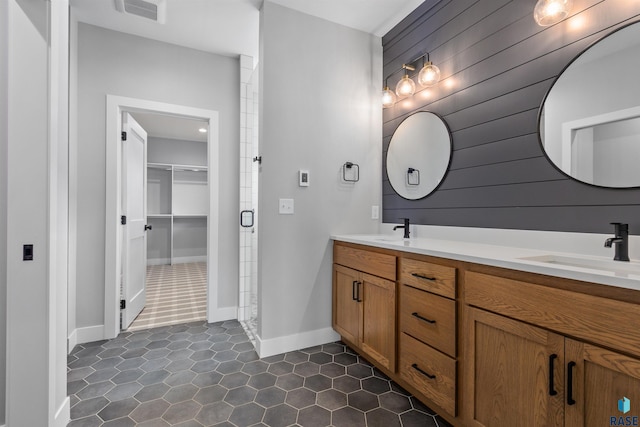 7324 E Twin Pines Ct, Sioux Falls, SD 57110 - bathroom featuring double vanity, a walk in closet, tile patterned floors, and baseboards