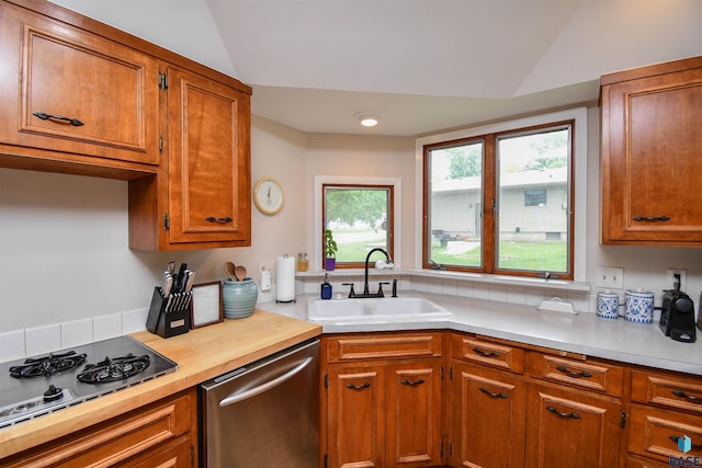 2804 S 1st Ave, Sioux Falls, SD 57105 - kitchen featuring appliances with stainless steel finishes, a sink, vaulted ceiling, brown cabinets, and light countertops
