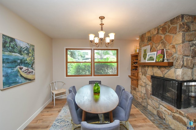 2804 S 1st Ave, Sioux Falls, SD 57105 - dining room with a chandelier, light wood finished floors, a fireplace, and baseboards